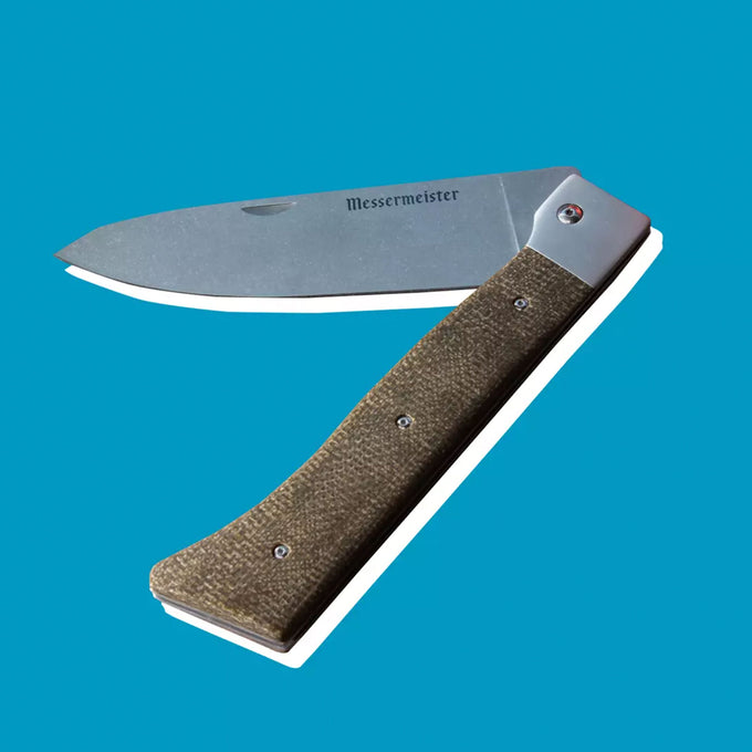 Adventure Chef Knife half folded on a blue background