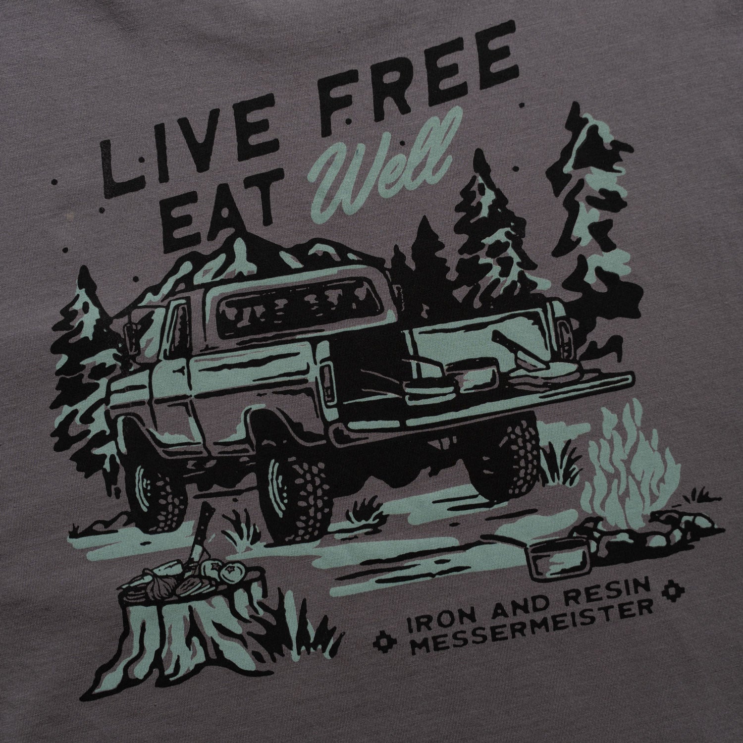 Messermeister and Iron & Resin T-shirt design with a truck, trees, and 'Live Free Eat Well' text on a dark background.