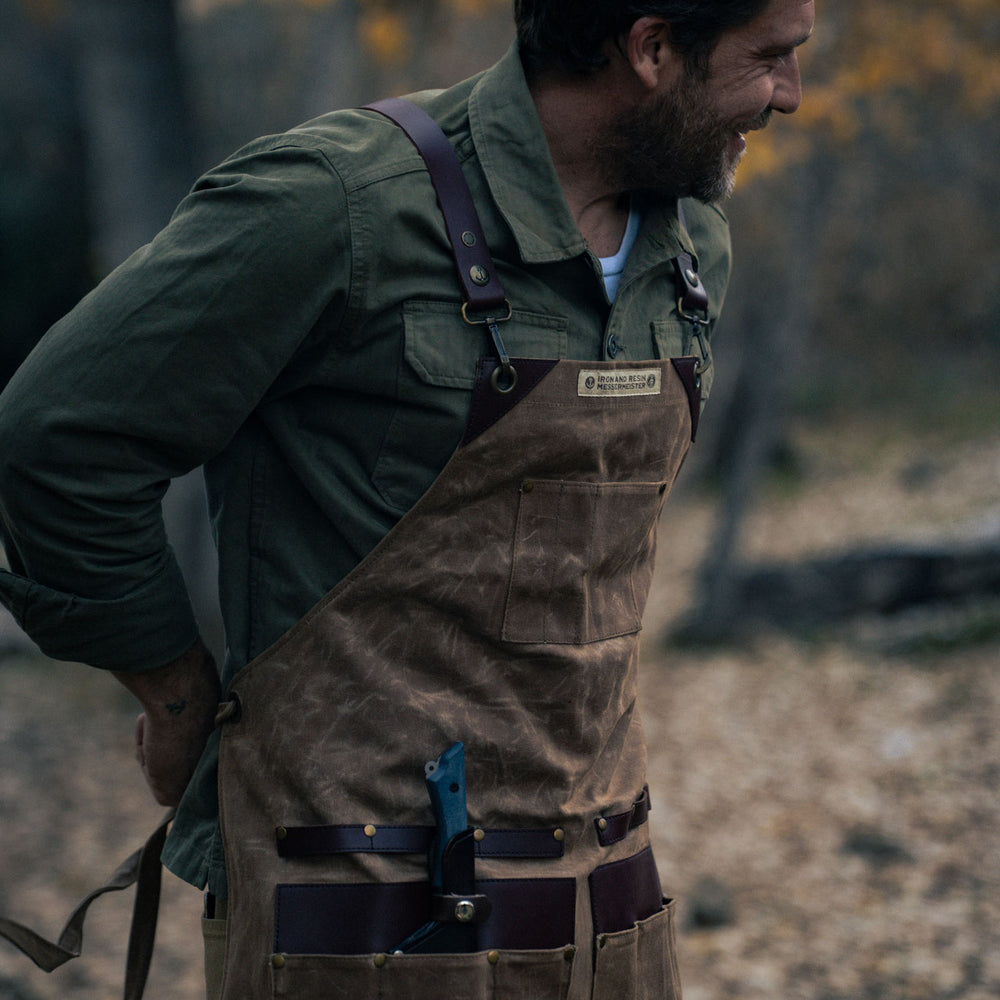 man tying the brown leather apron outdoors
