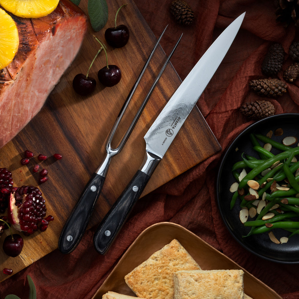 Messermeister Avanta Damascus Carving Set on a wooden cutting board with ham, green beans with almond slivers, pomegranate and fall decorations.