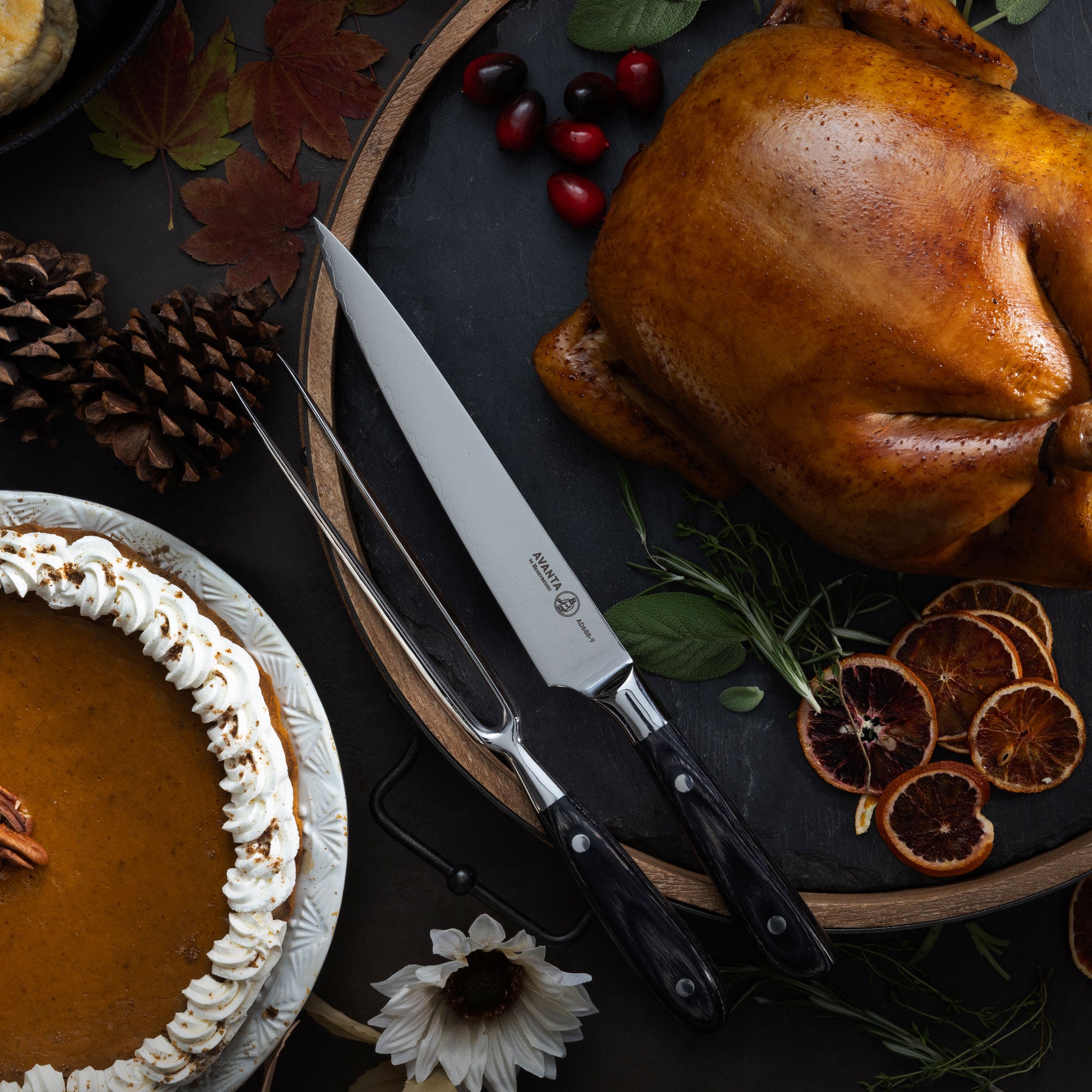 Roasted turkey on a platter with a pumpkin pie, Messermeister Avanta Damascus Carving Set, and fall decorations.