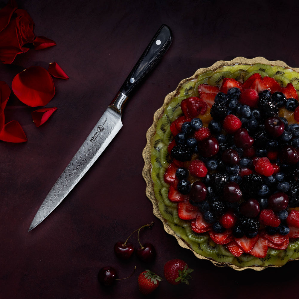 Berry tart with a Messermeister Avanta Damascus Slicing Knife on a dark red surface