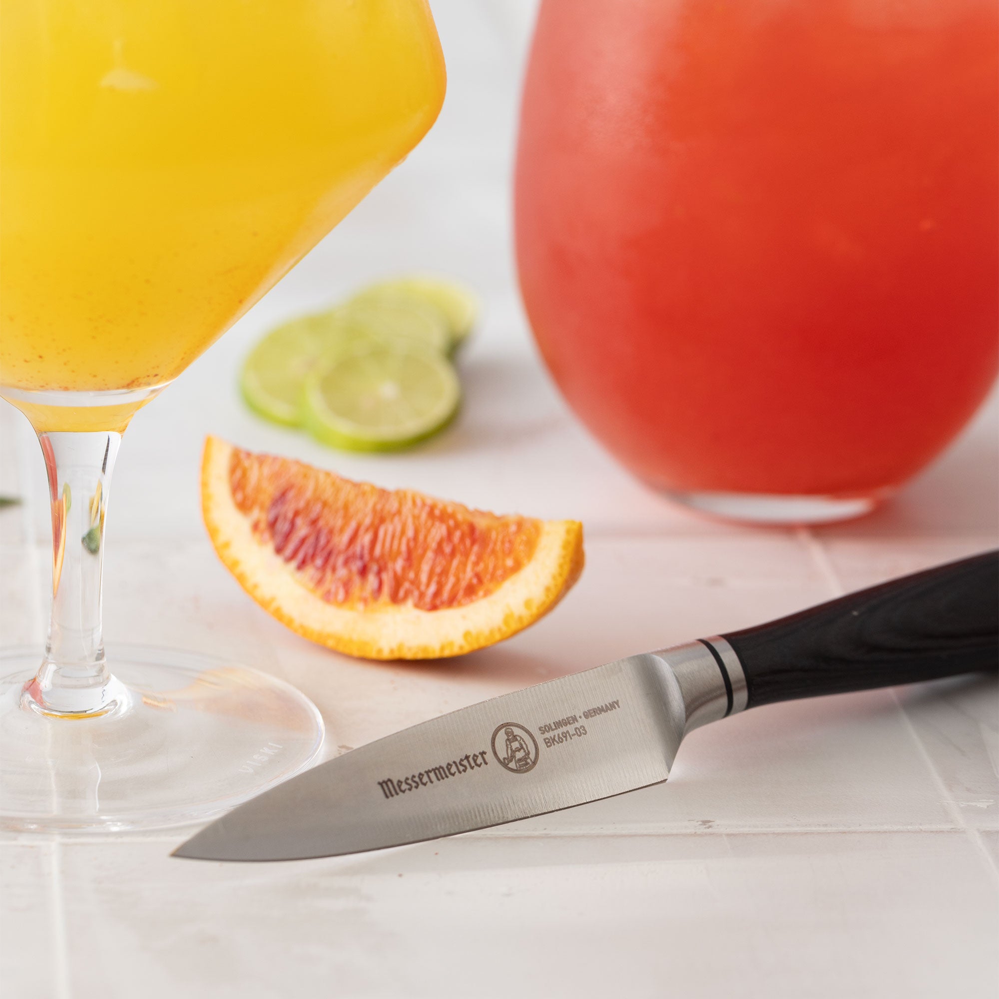 Messermeister Blacksmith Paring Knife pictured on bright bar counter top with cocktails and sliced citrus fruits
