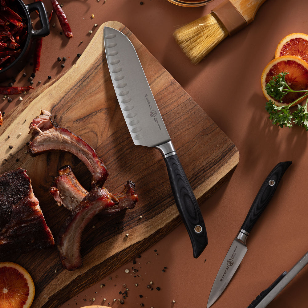 Messermeister Blacksmith Santoku Knife pictured with Ribs, Citrus and spices on terracotta background and wood cutting board