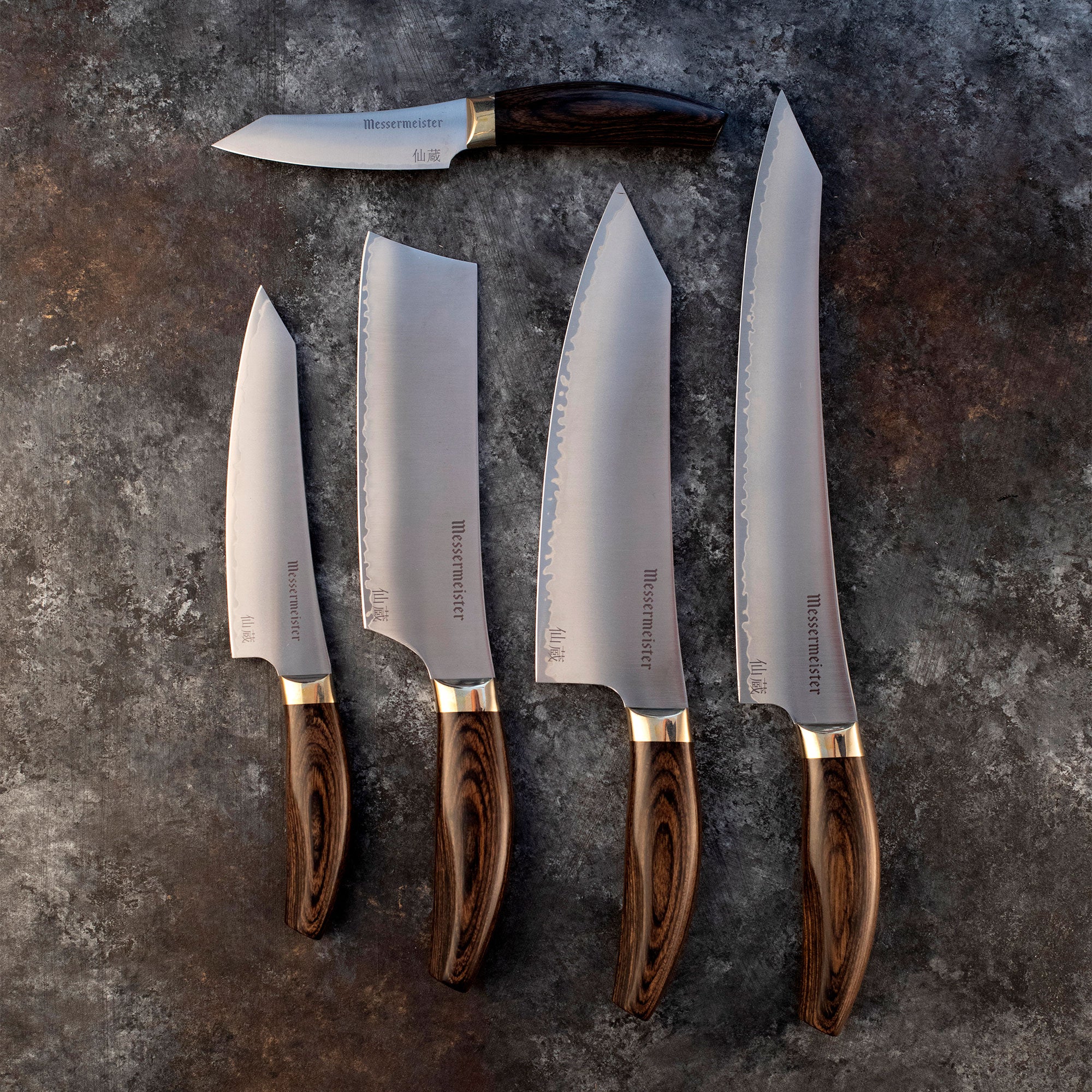 Messermeister Kawashima Collection Knives, Slicing, Chef, Nakiri, Utility, Paring Knife on a gray and brown surface