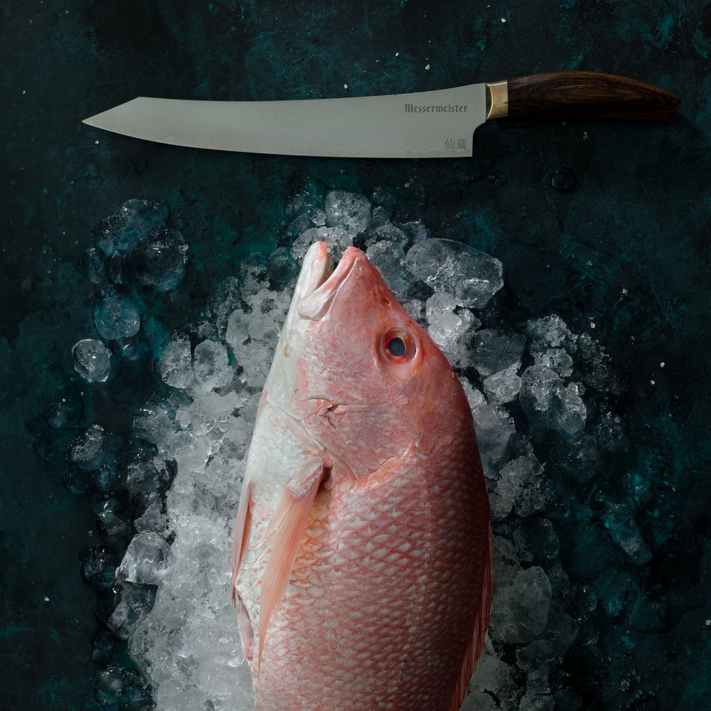 Messermeister Kawashima Slicer on dark background with fish on ice