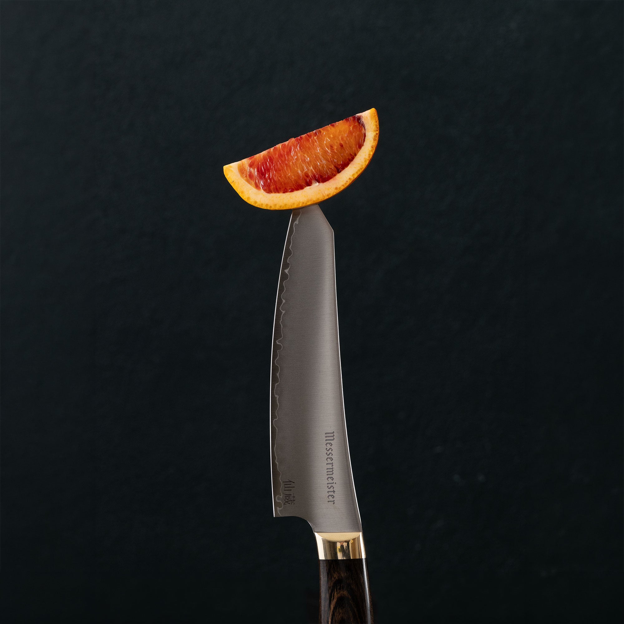 Messermeister Kawashima Utility piercing Citrus Wedge on dark background
