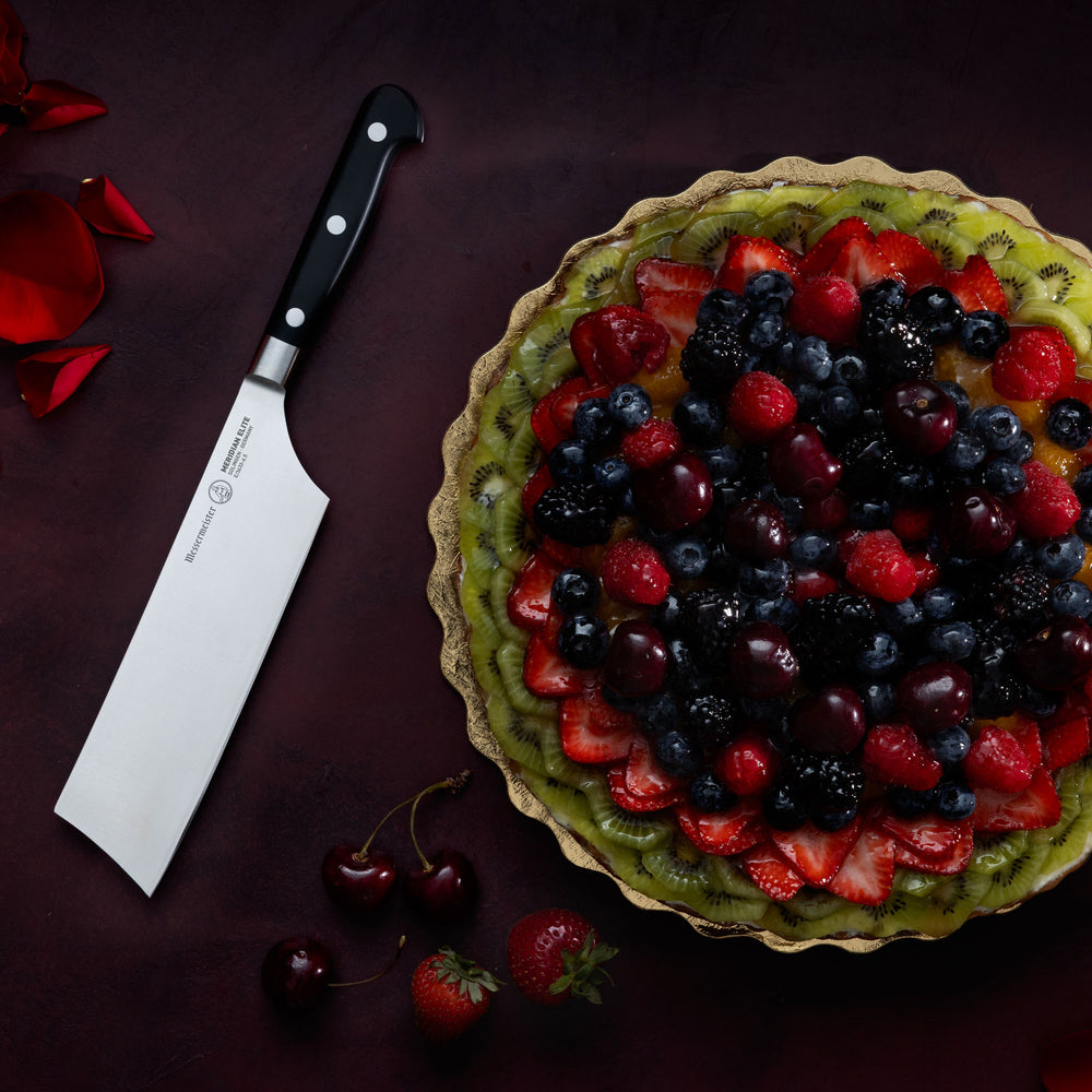 Messermeister Meridian Nakiri on Dark Background with Fruit Tart and roses
