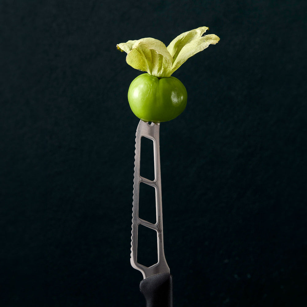 Messermeister Petite Messer Tomato Knife Stabbing Tomato on a dark background