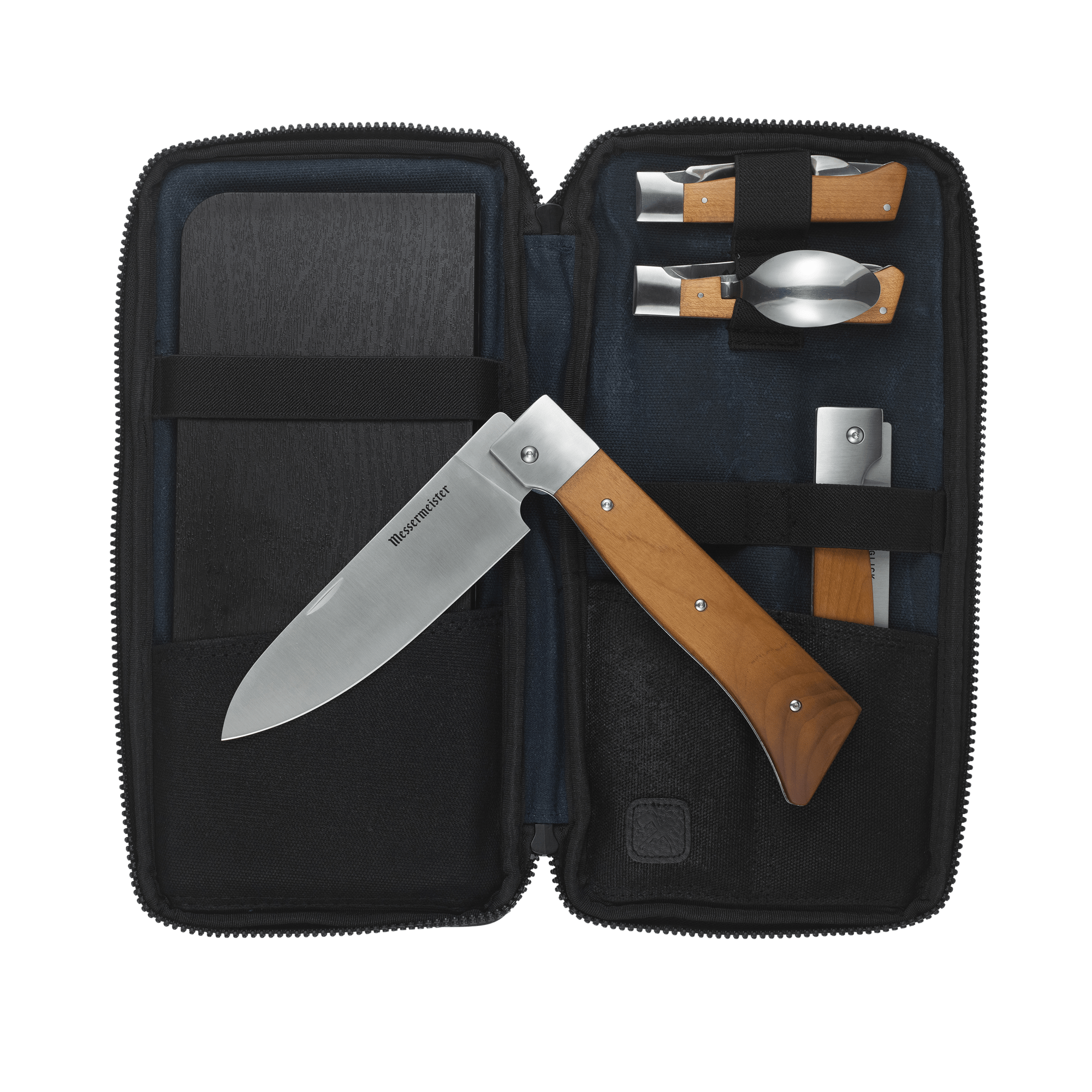 Messermeister Adventure Chef Maple Summit 6 Piece set showing the 6 inch folding Chef's Knife removed and laying on top of the open zippered carrying case with the folding utensil, folding peeler and parer, folding fillet knife and faux wood cutting board tucked inside.