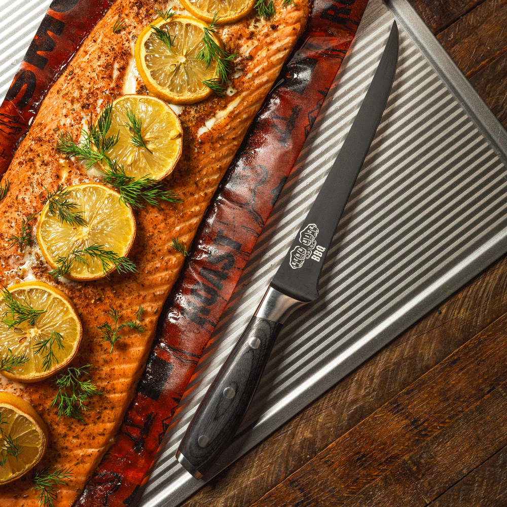 Messermeister Avanta Kendrick BBQ Fillet Knife next to grilled salmon garnished with lemon slices on a metal tray