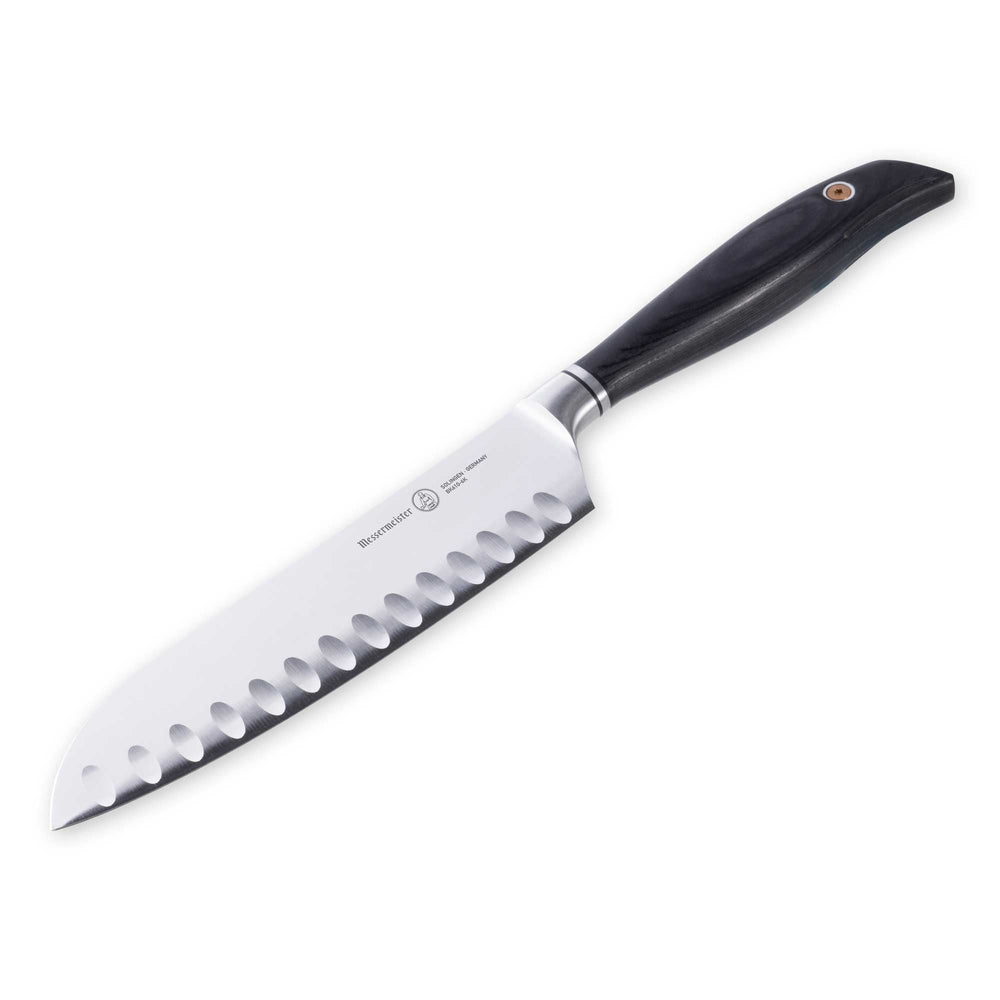 Messermeister Blacksmith 6.5-Inch Kullens Santoku Knife with a hammered high-carbon stainless steel blade and kullens granton edge, angled downward to showcase the razor-sharp cutting edge and ebony pakkawood handle