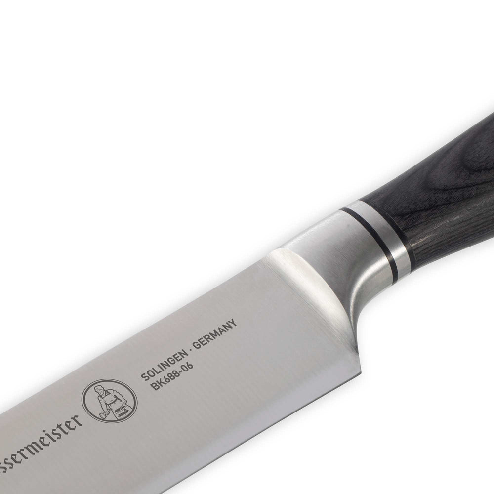 Close-up of the Messermeister Blacksmith 6-Inch Utility Knife handle, featuring smooth ebony pakkawood with ergonomic shaping and polished rivets, designed for a secure, comfortable grip and balanced control during kitchen prep