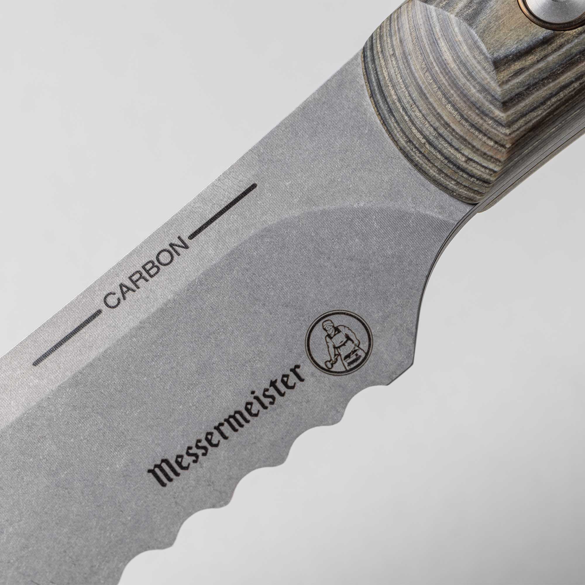 A close up view of the 9 inch Carbon Bread Knife serrated heel and logo