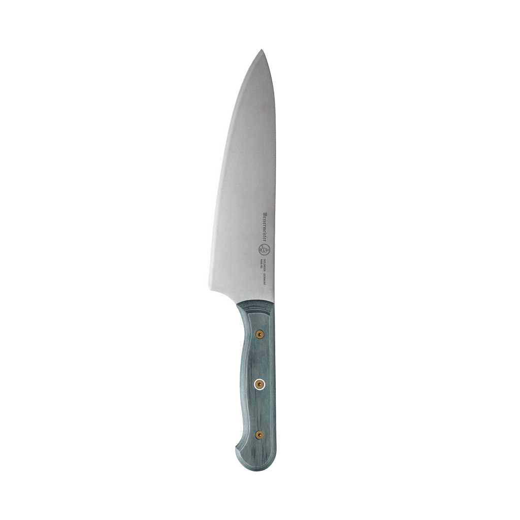 Messermeister Custom Blue 8-inch chef’s knife featuring a stainless steel blade and a bold blue ergonomic modular handle with textured Indigo Evergreen scales, highlighting the sharp cutting edge and balanced profile