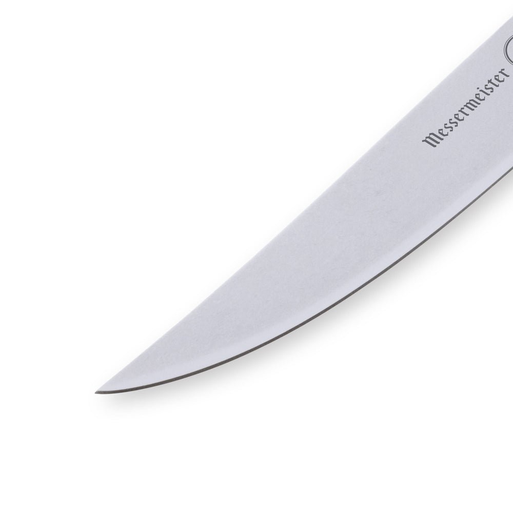 Close-up of the Messermeister Custom Blue steak knife tip, highlighting the razor-sharp fine-edge stainless steel blade, precise pointed tip geometry, satin finish, and refined craftsmanship with dramatic lighting emphasizing sharpness and detail.