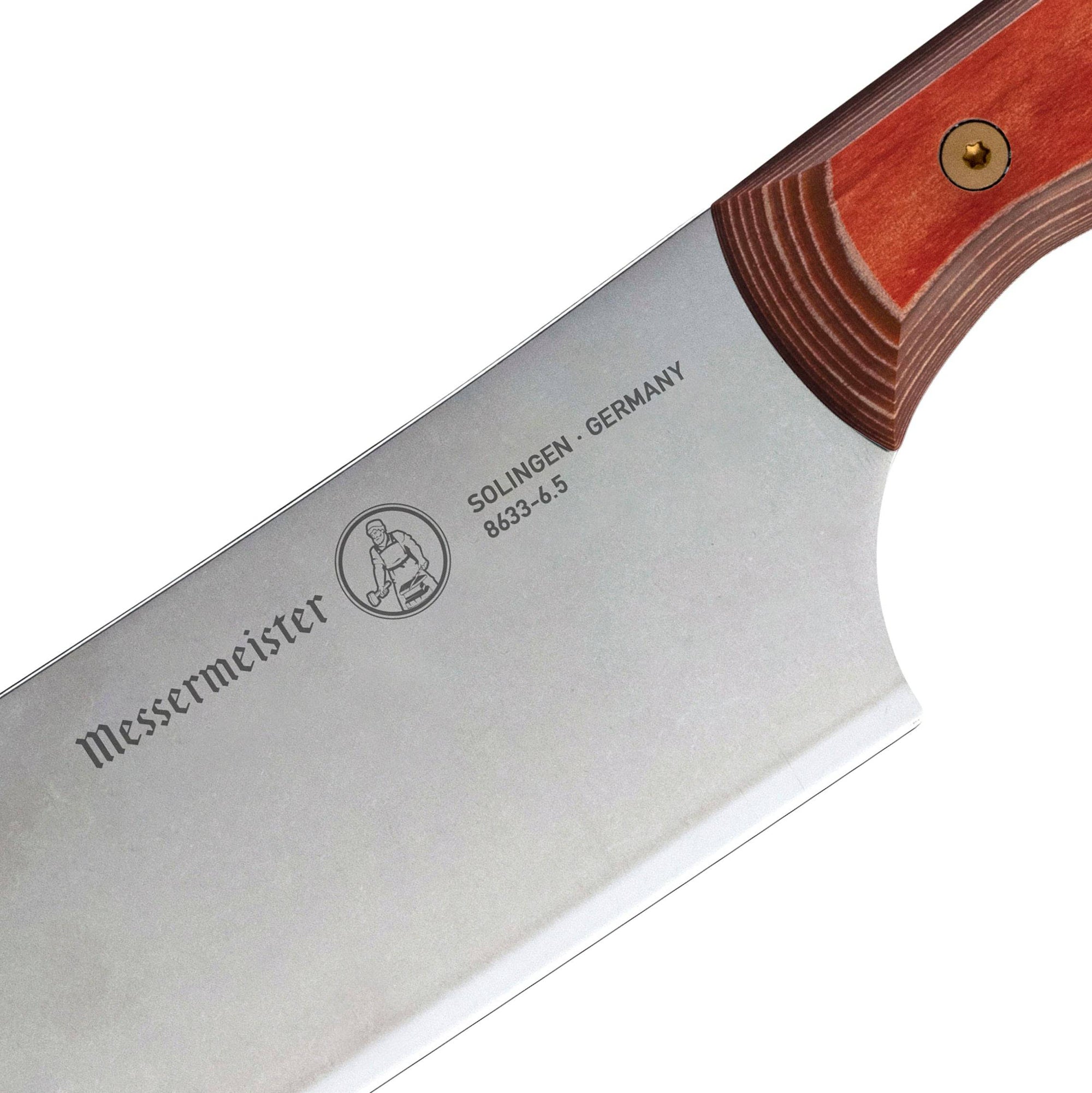 Close-up of the heel of a 6.5-inch Messermeister Custom Red Nakiri knife, highlighting the thick base of the straight stainless steel blade where it meets the red ergonomic handle
