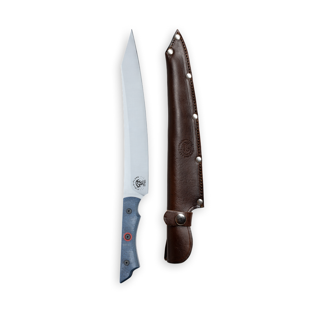 INR x Messermeister Slicer 9 inch Denim Micarta with Red G10 Liner Handle and red center rivet next to leather sheath on a plain background