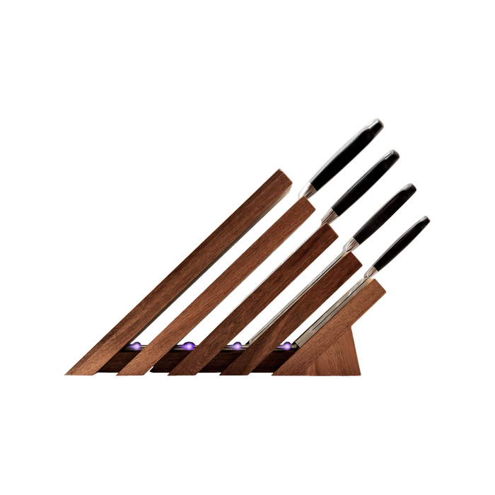 Messermeister Next Level Magnetic Knife Block and UV light with a single black handled knife stored on each of the 4 slots. Block is showing the side view with handles to the right.