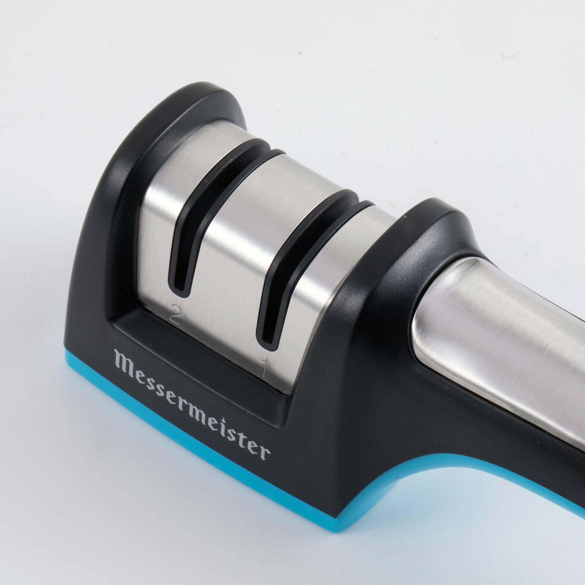 A close up of the sharpening mechanics on the Messermeister Pull Through Sharpening slots and the 1st portion of the handle. the Item is pointed to the top left.