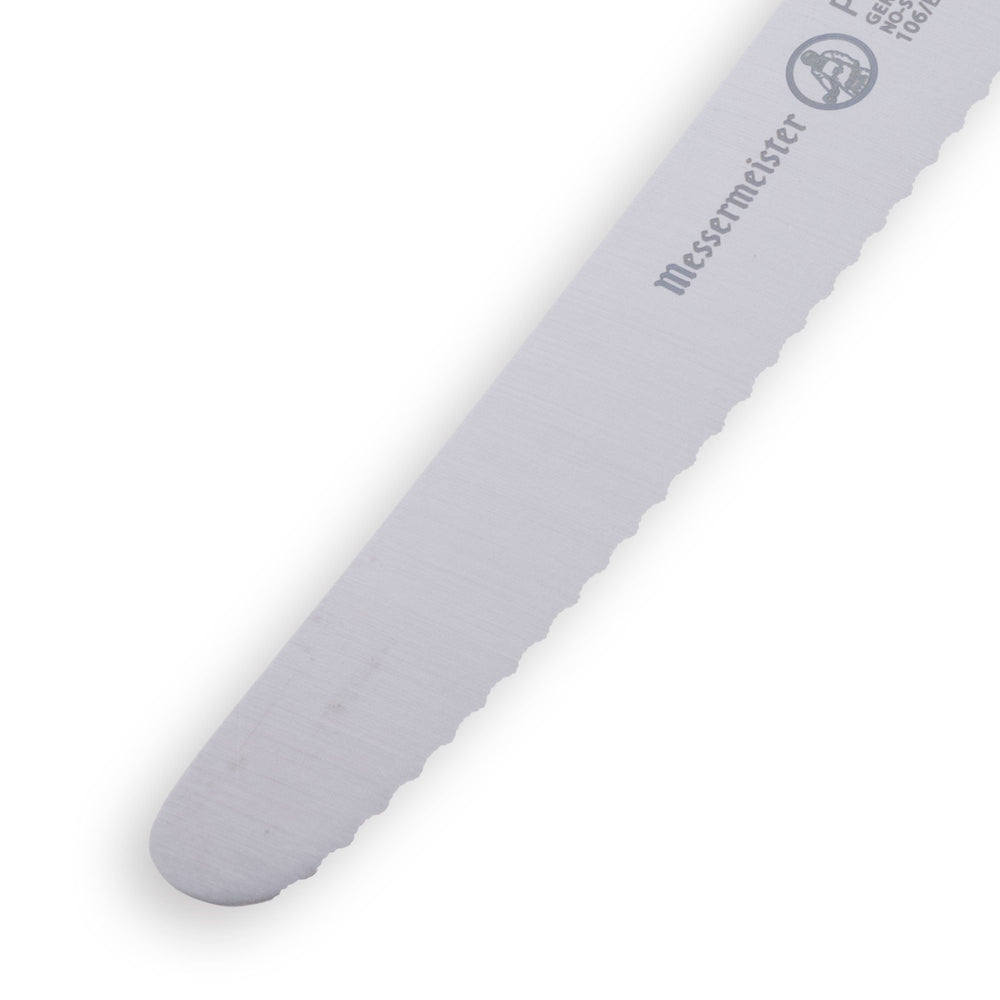 Close-up view of pointed tip on 4.5 inch serrated tomato knife showing fine serrated edge for controlled slicing of soft produce