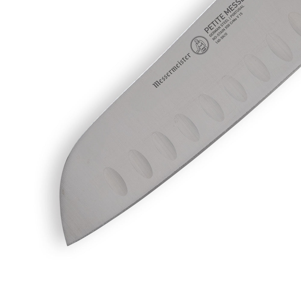 Precision tip of Petite Messer Orange Santoku knife with granton edge visible