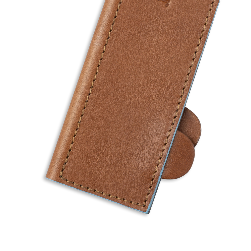 Messermeister 10.5 inch Saddle Brown Leather Magnetic Edge Guard Soft Rubber Magnets to Secure Knife on a plain background close up on opener tabs