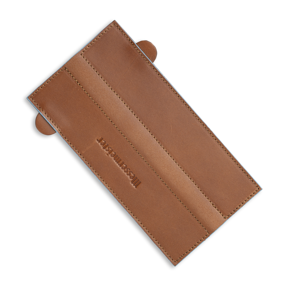 Messermeister 6.5 inch Saddle Brown Leather Magnetic Edge Guard Soft Rubber Magnets to Secure Knife laid out flat