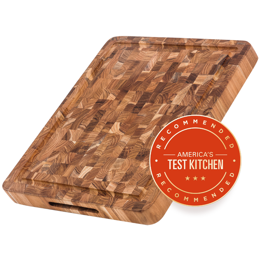 Angled top-down view of the TeakHaus butcher block carving board, 16 x 12 inches, highlighting its deep juice groove designed to catch meat juices and keep countertops clean during carving and food preparation.