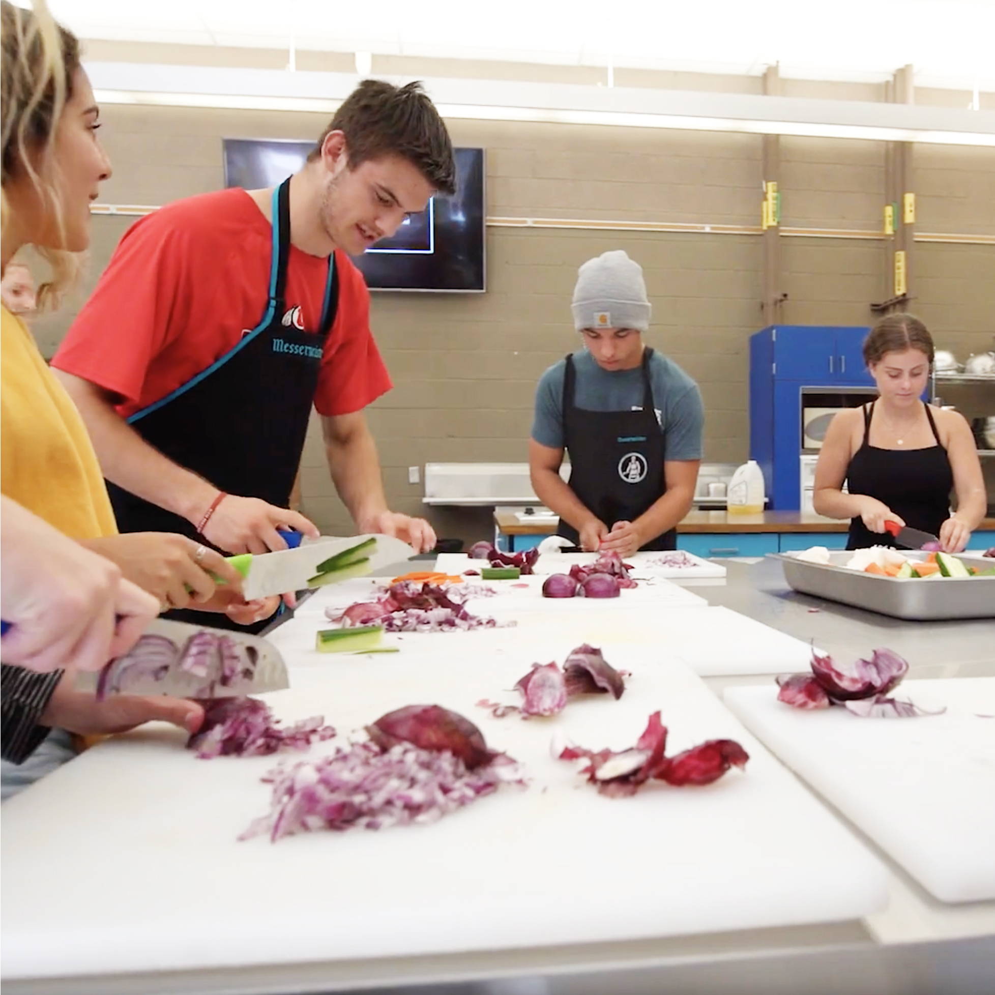 Group of students preparing food in a kitchen setting with Messermeister Pro Series knives