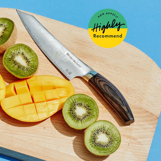 Sliced mango and kiwi on a wooden cutting board with a Kawashima Utility knife, against a blue background with text "Bon Appetit Highly Recommend"