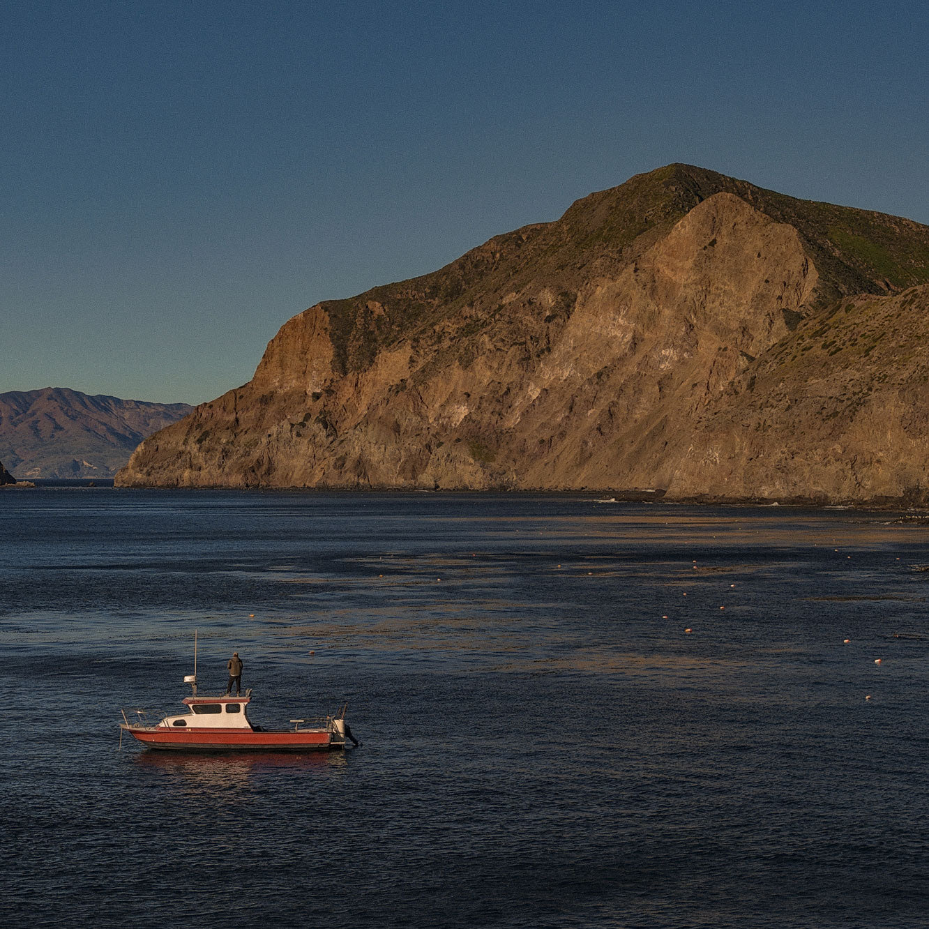 Boat in the water with a mountainous island in the background