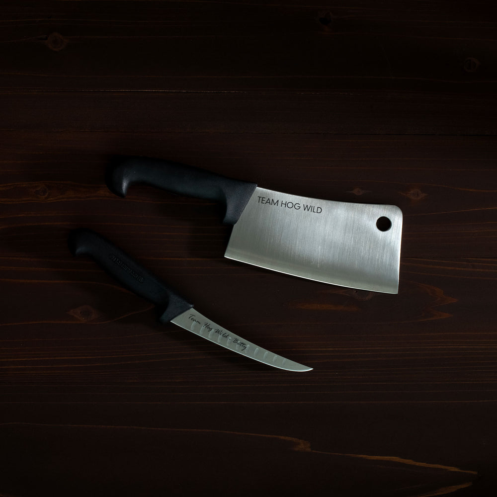 Two knives on a wooden surface with 'Team Hog Wild' branding.