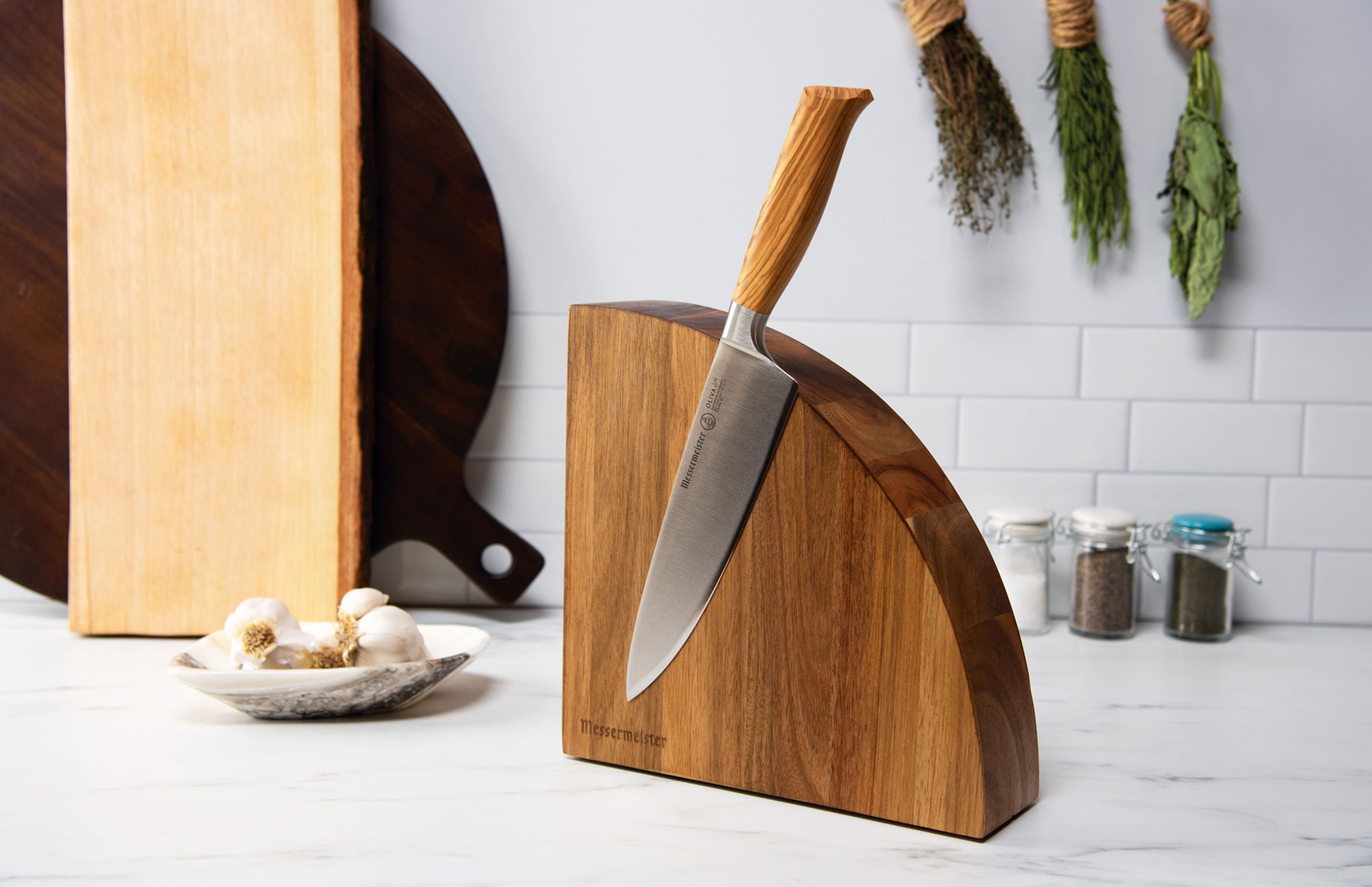 Quarter Round Magnetic Knife Block with Oliva Chef's Knife on Table with Bowl of Garlic