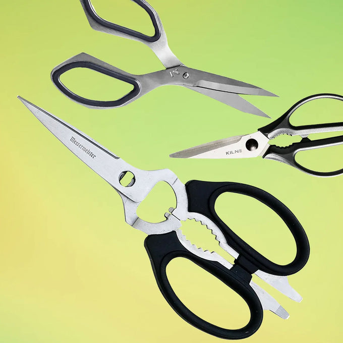 Pair of kitchen shears with black handles on a gradient green and yellow background