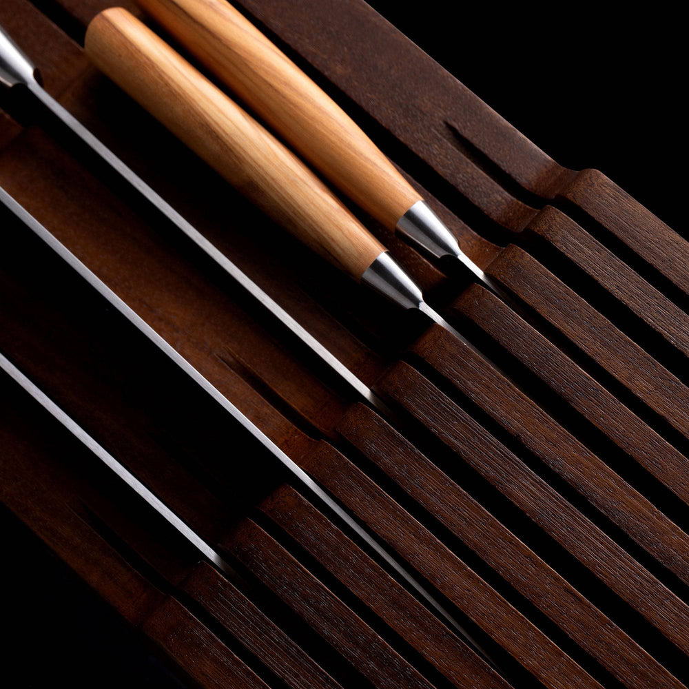 Messermeister 11 Slot Contemporary Acacia In-Drawer Knife Holder shows a close up of 5 Olive Wood knives situated within the slots. Knife handles pointing to the left.