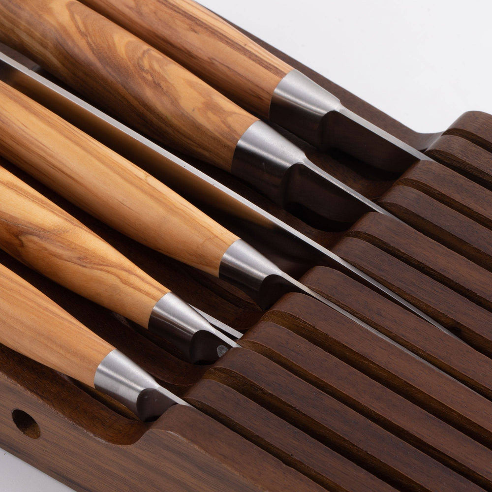 Messermeister 11 Slot Contemporary Acacia In-Drawer Knife Holder shows a close up of 7 Olive Wood knives situated within the slots. Knife handles pointing to the left.
