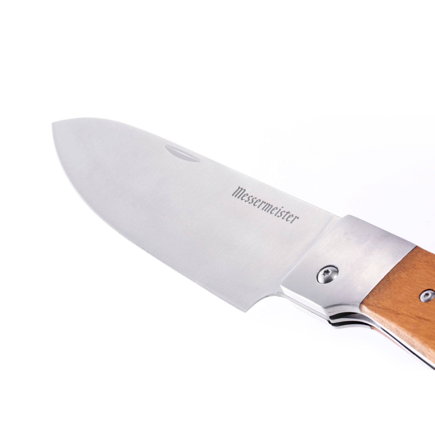 A close up view of the handle of the Messermeister Adventure Chef Folding 6 inch Chef's Knife with Maple handle