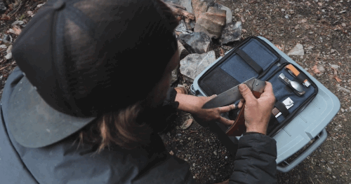 Video of person at a campsite pulling and extending the Adventure Chef 6 inch Chef's knife that was stored inside the 6 piece kit with a dog watching from the side