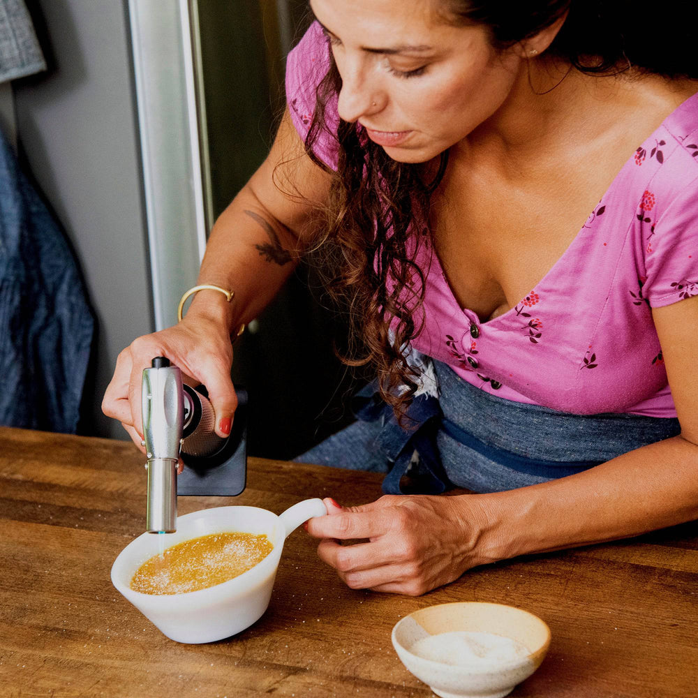 Messermeister Cheflamme Culinary Torch caramelizing the sugar topping on a crème brûlée, creating a crisp golden crust with a precise adjustable flame for professional dessert finishing and gourmet kitchen presentation