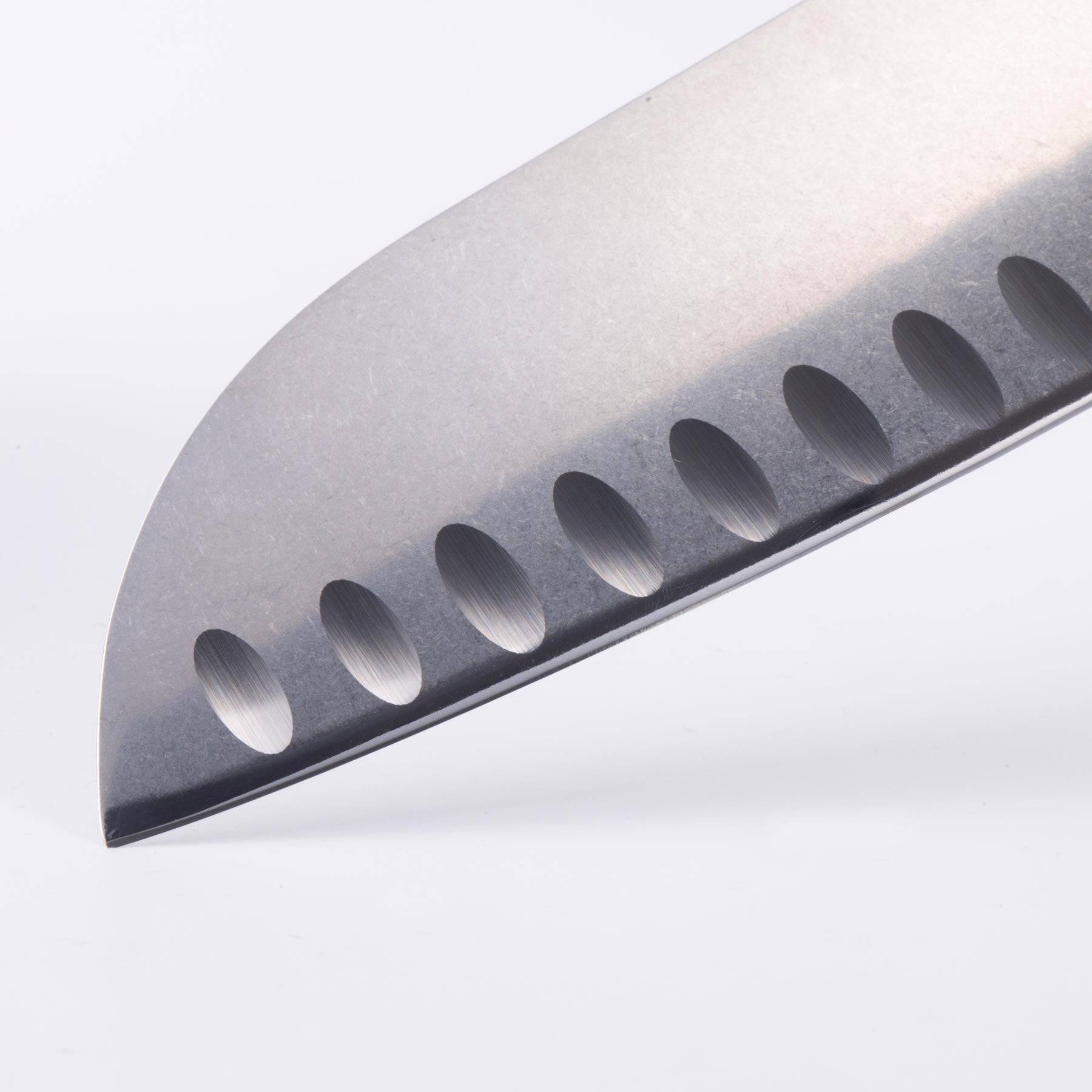 Close-up of Messermeister custom santoku knife tip highlighting sharp blade point and kullens