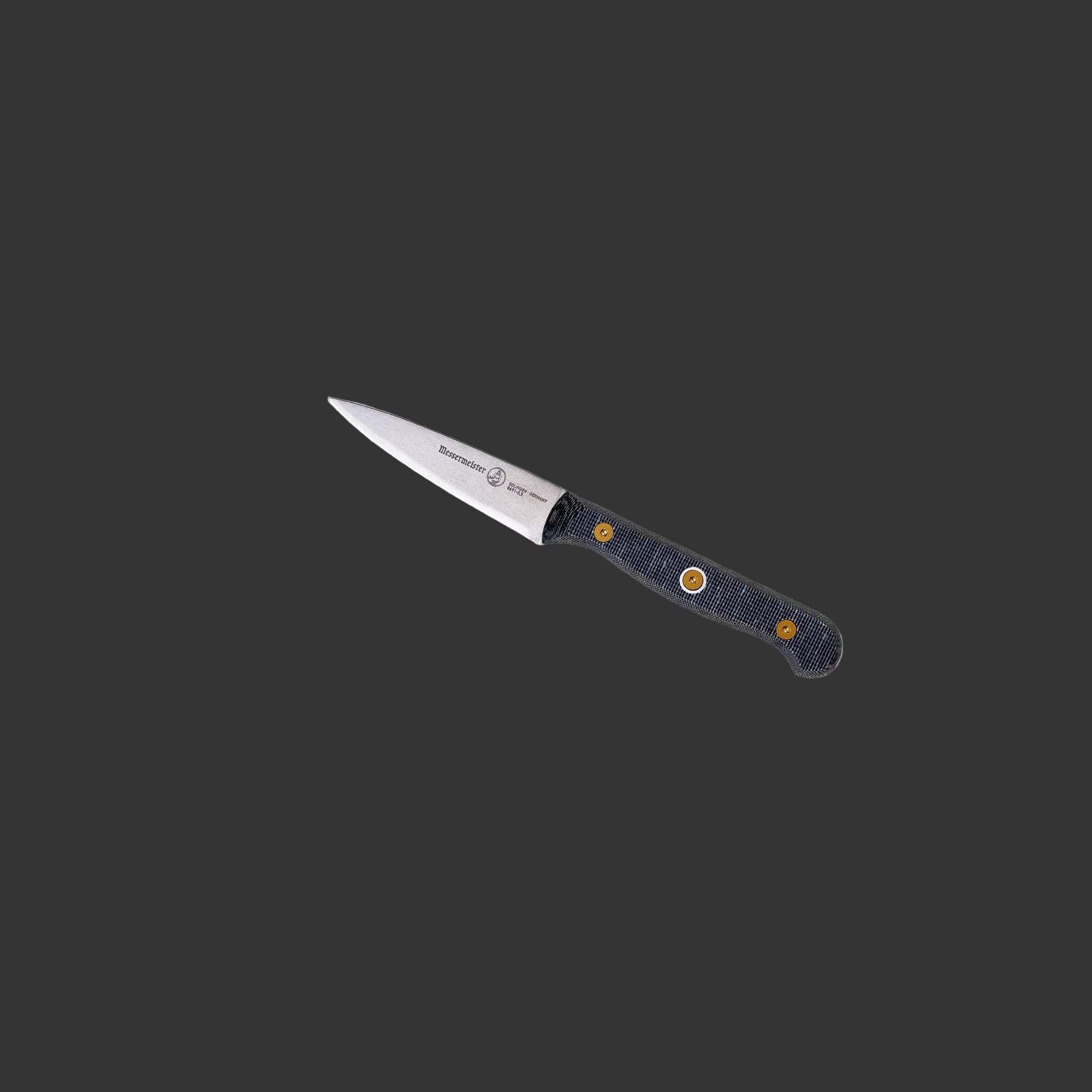 Angled upward close-up of the handle on a Messermeister Custom 3.5-inch paring knife, showcasing the textured linen micarta grip with layered pattern, ergonomic contours, and riveted modular construction, emphasizing the secure non-slip hold
