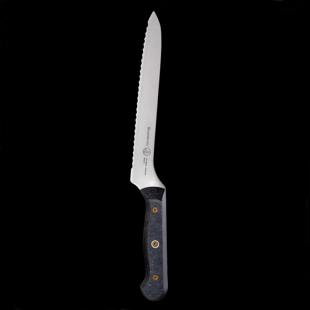 Upright view of Messermeister custom offset bread knife highlighting scalloped serrated edge and  linen micarta handle