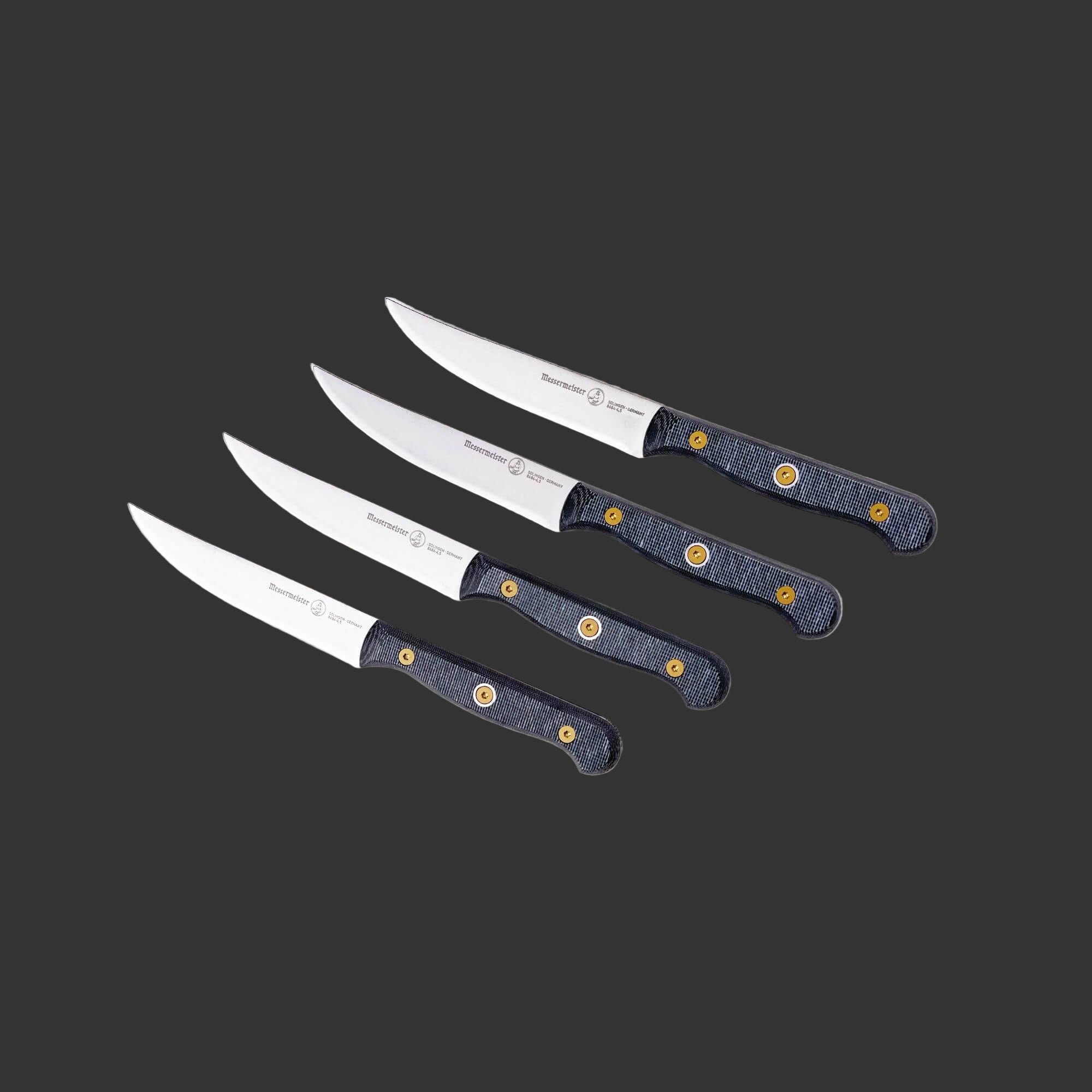 Angled upward view of a four-piece Messermeister Custom steak knife set with 5-inch blades highlighting the stainless steel blades, sharp cutting edges, and ergonomic modular handles with textured linen micarta handles
