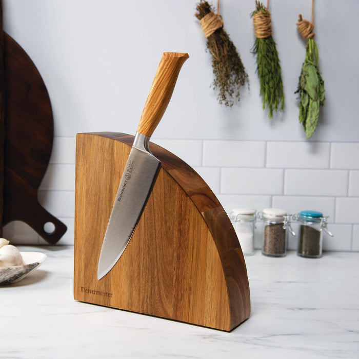 The Messermeister Quarter moon magnetic wooden block with 1 Olive wood handled knife attached. Resting on a marble counter with herbs hanging and spices bottled in the background.