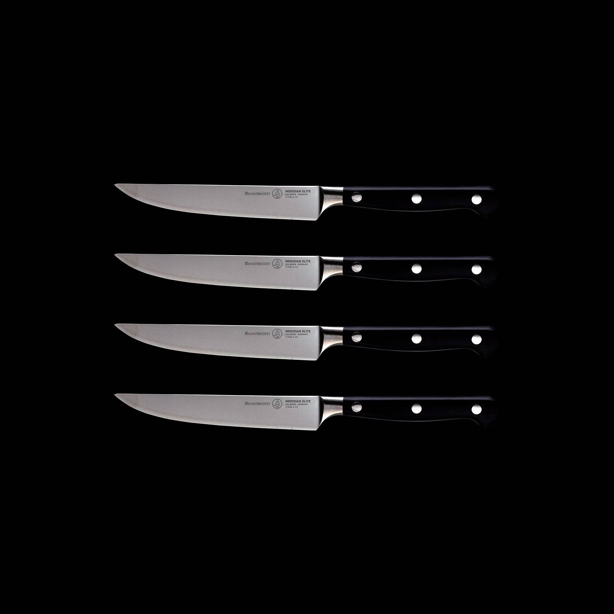 A set of four Meridian Elite fine edge steak knives with triple rivet black handles and stainless steel blades full view pointing left