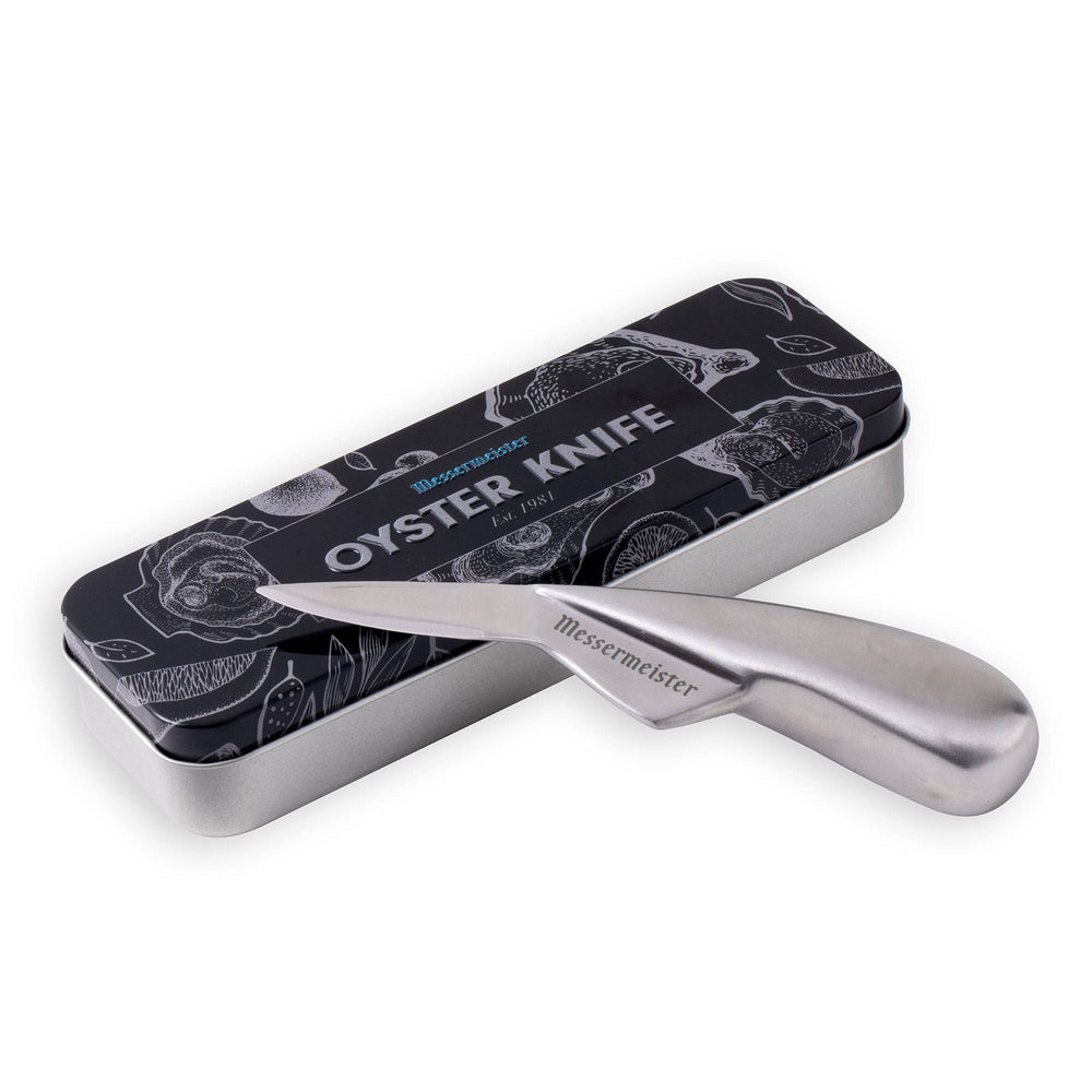 Messermeister Stainless Steel 6.5 inch Oyster Knife with ergonomic handle and curved tip shown resting on the side of the metal gift box