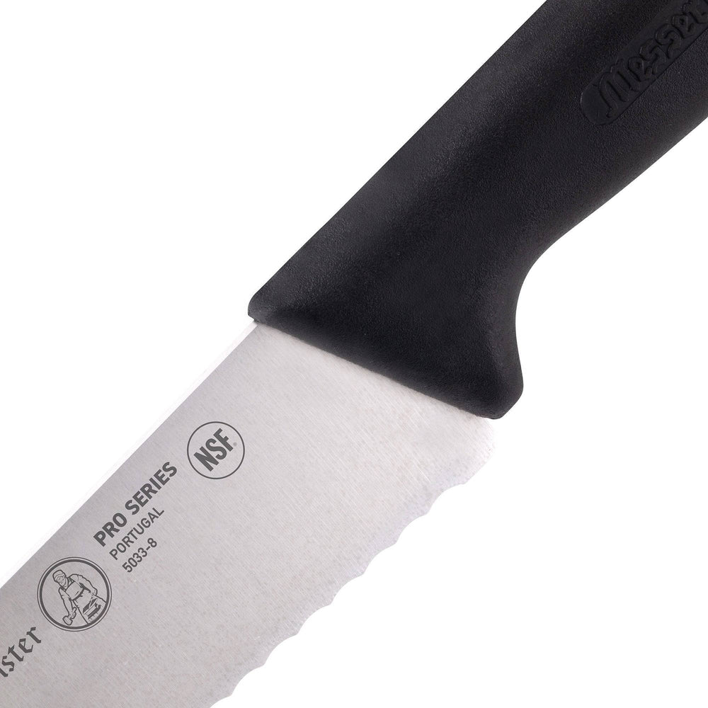 Detail of heel section on Messermeister Pro Series 10-inch scalloped baker’s knife highlighting serrated stainless steel blade and ergonomic non-slip black polyfibre handle connection