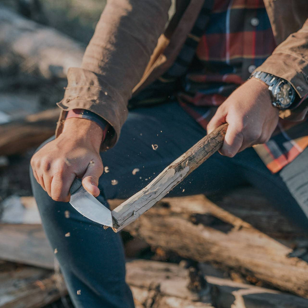 Messermeister Overland Chef Utility Knife - 4.5" carving a wooden stick outdoors